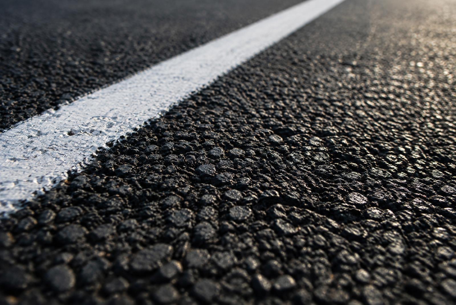 Close-up of fresh asphalt with a crisp painted stripe